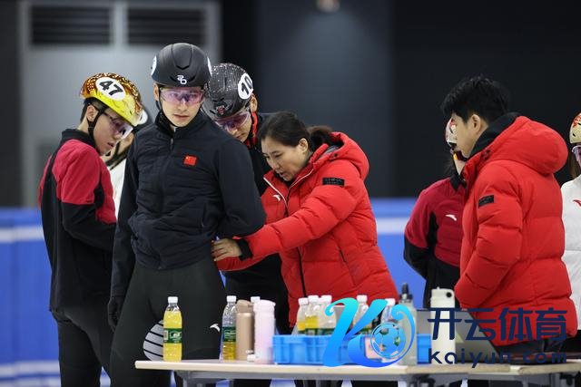 ↑ 中国短说念速滑队培育张晶（中）在训导中为队员刘少昂（左二）整理服装。 新华社记者 张晨 摄